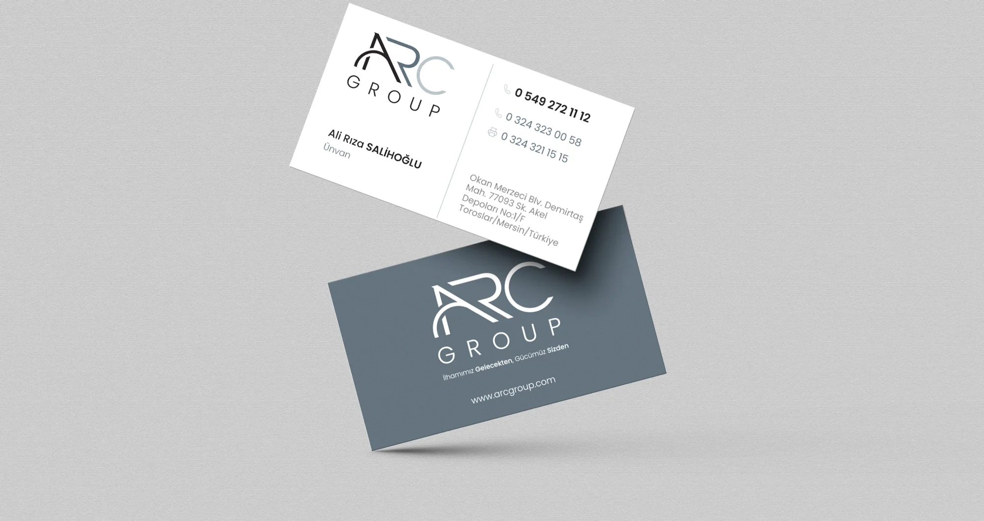 Two floating business cards: the white front with logo and contact details, the A Gray back with a white logo, slogan and web address.