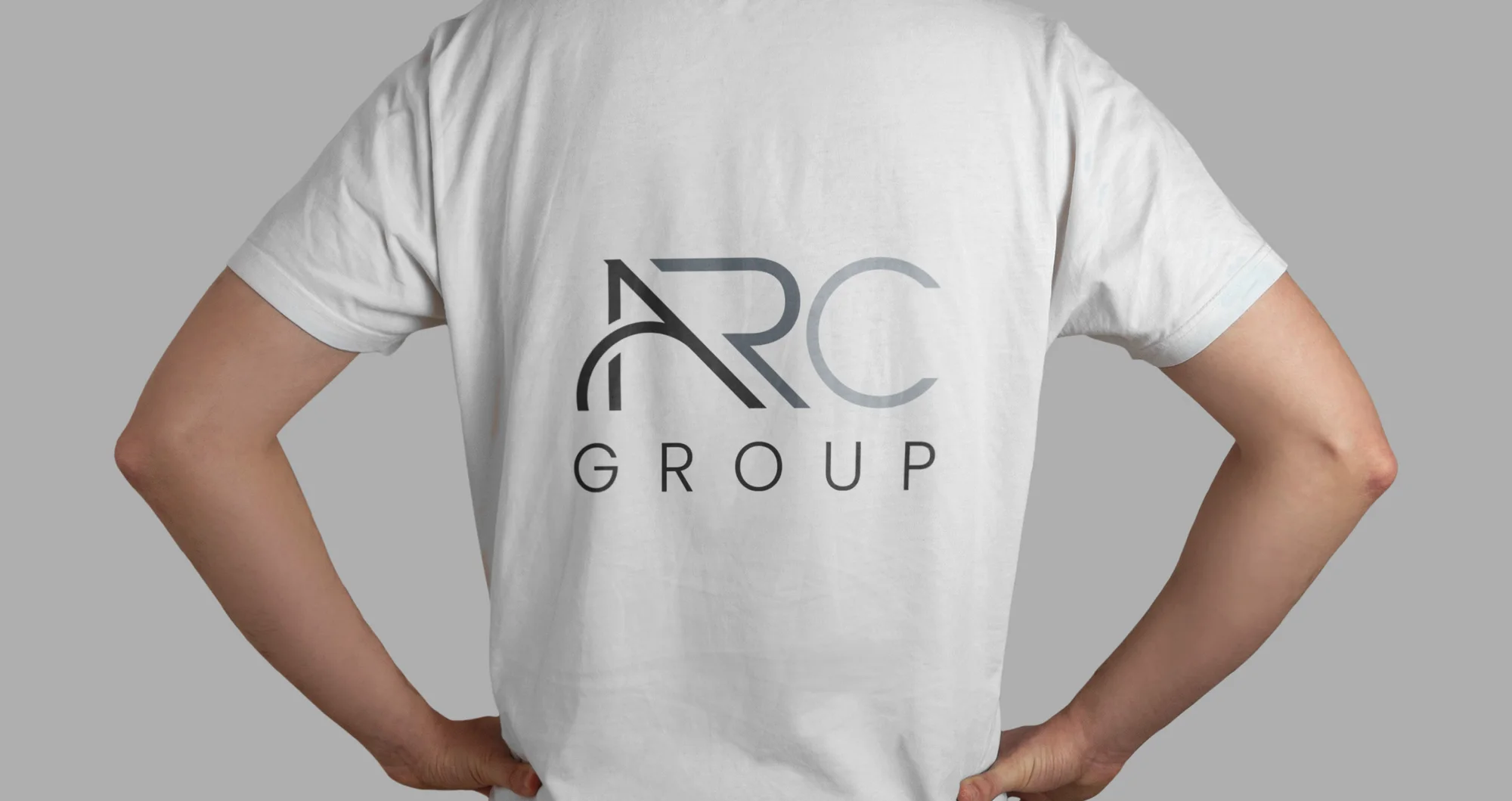 A large three-colour ARC Group logo on the back of a white T-shirt.
