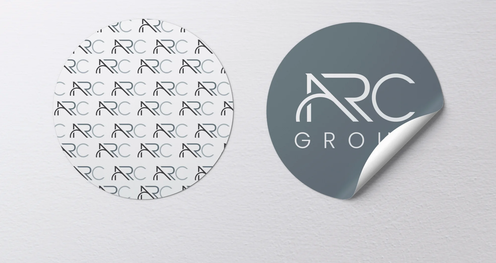 Two round stickers: one white covered in the ARC watermark pattern, one A Gray with a peeling corner.