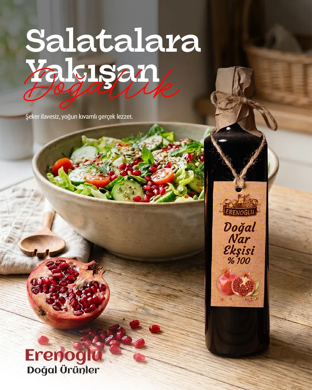 A salad bowl, a pomegranate and a bottle of pomegranate molasses on a wooden table; "Salatalara Yakışan Doğallık".
