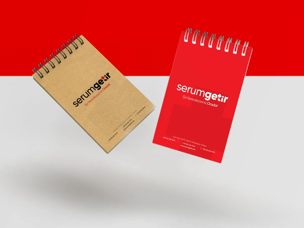 Two spiral notepads, one kraft and one red, with the logo.